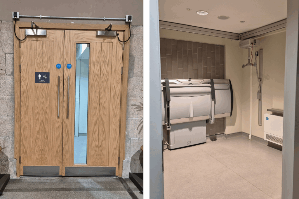 Two photos, one on the left of some light wooden double doors with a male and disabled toilet, (space to change), sign on them. The photo on the right is of the space to change through the doorway, with a hoist table against the wall, and some bars to hold on to.